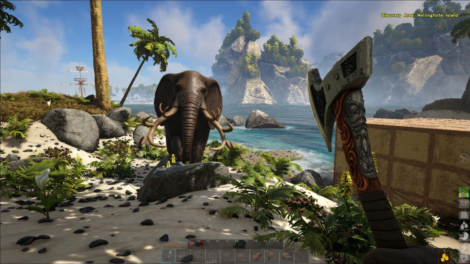 First-person perspective holding an ornate axe facing a large mammoth-like creature on a tropical beach