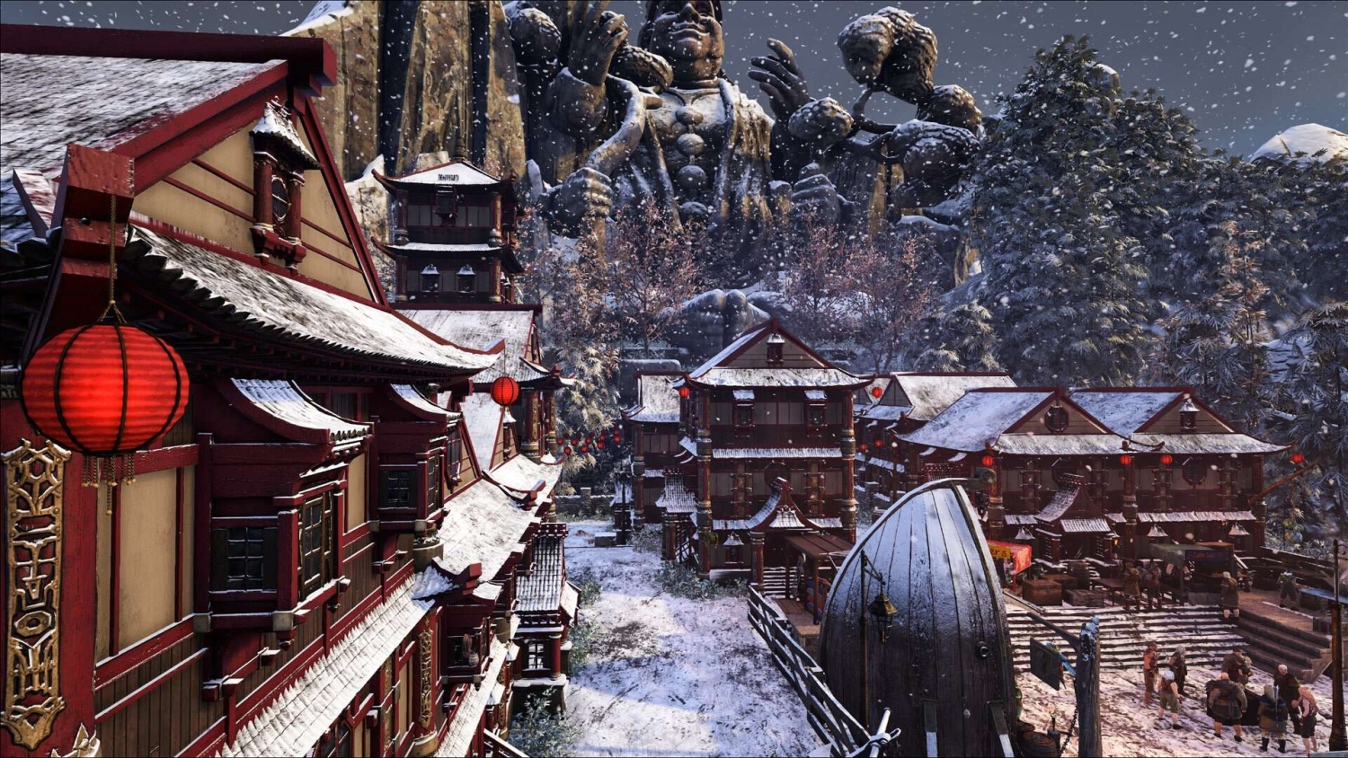 Snow-covered village with red and cream traditional buildings and large stone statues in the background