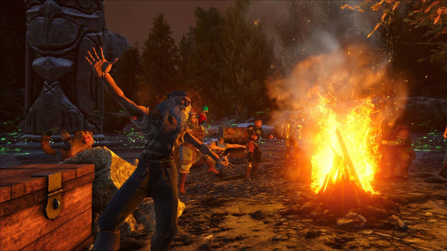 Characters gathered around a large campfire in a forest clearing surrounded by autumn trees and a wooden totem