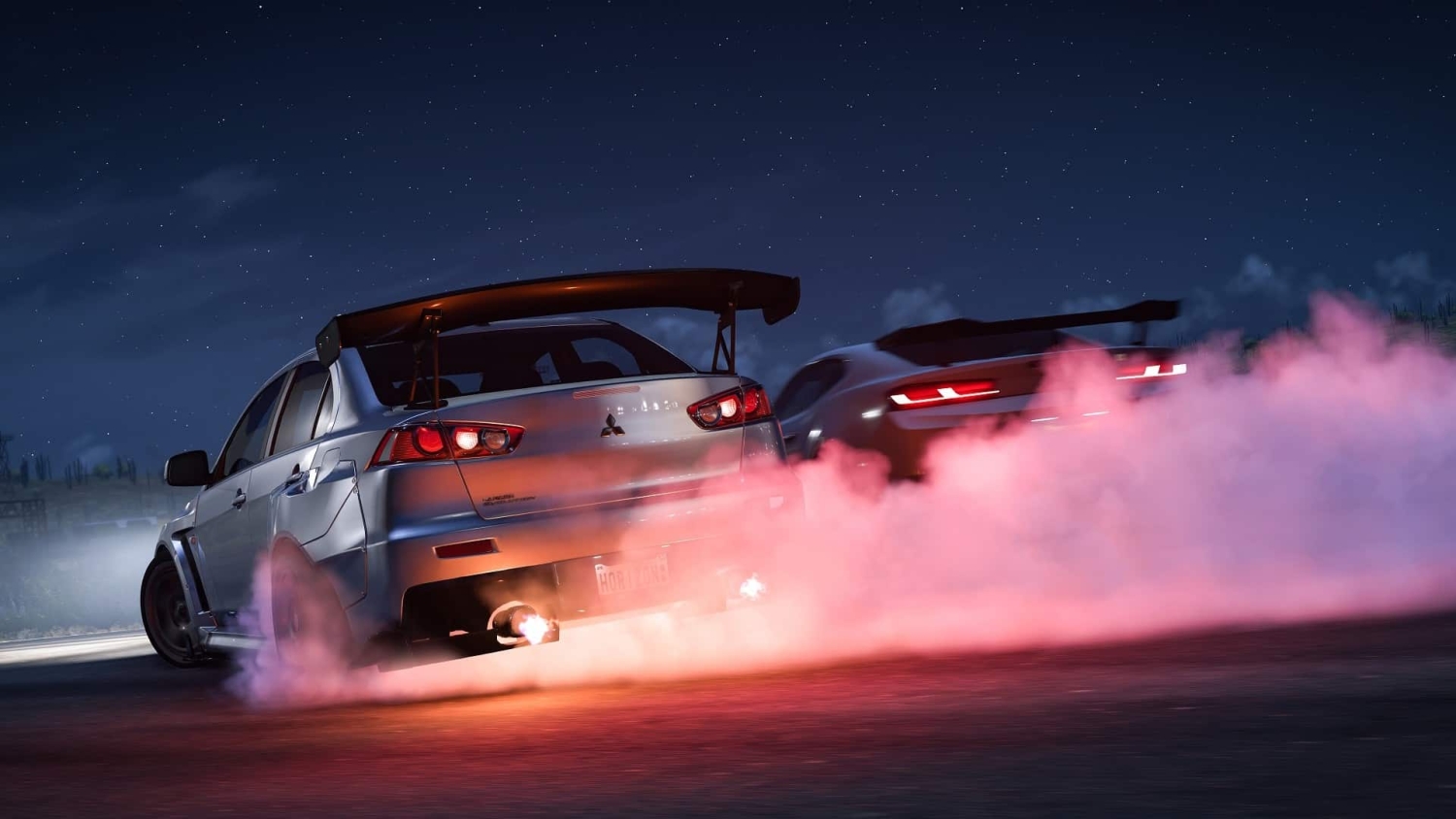 Two silver sports cars drifting on a road at night with red smoke and flames coming from the exhaust