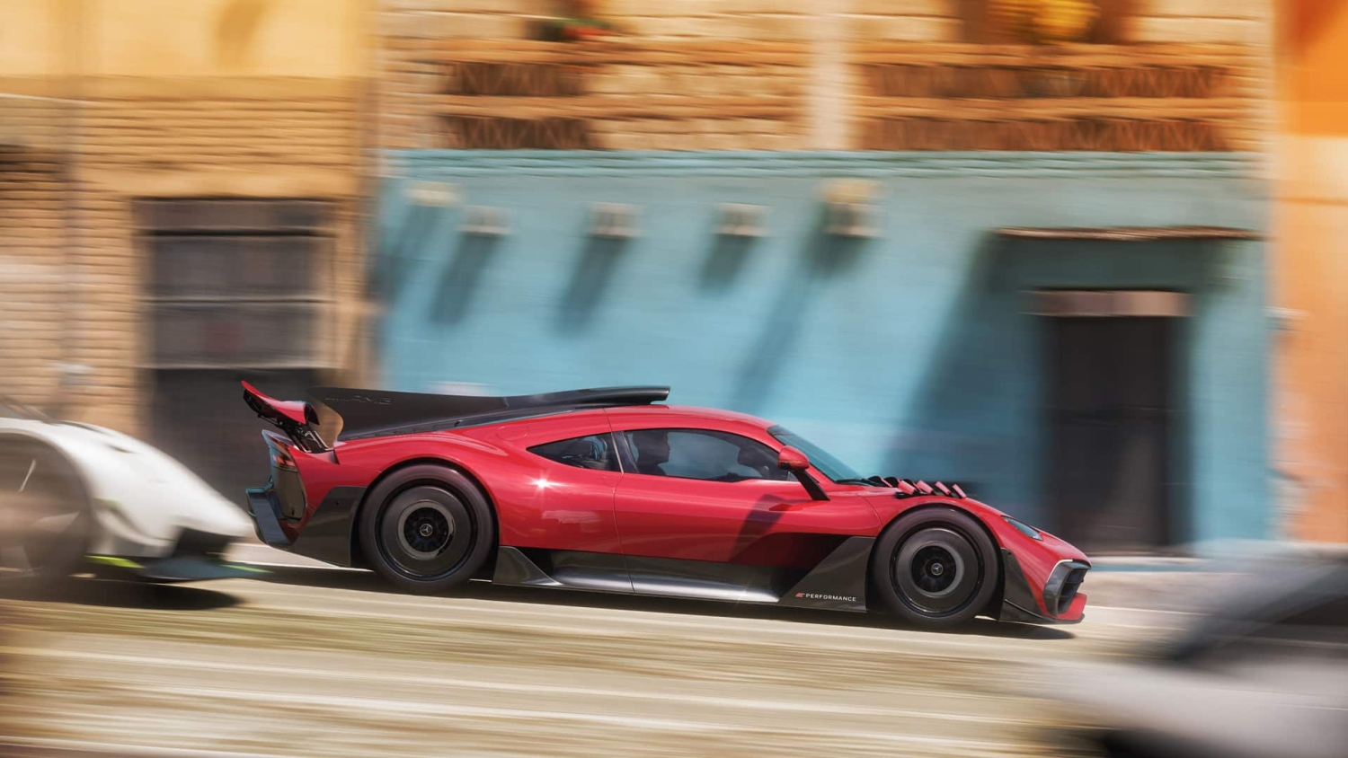 Red sports racing car speeding past colourful buildings with motion blur effect