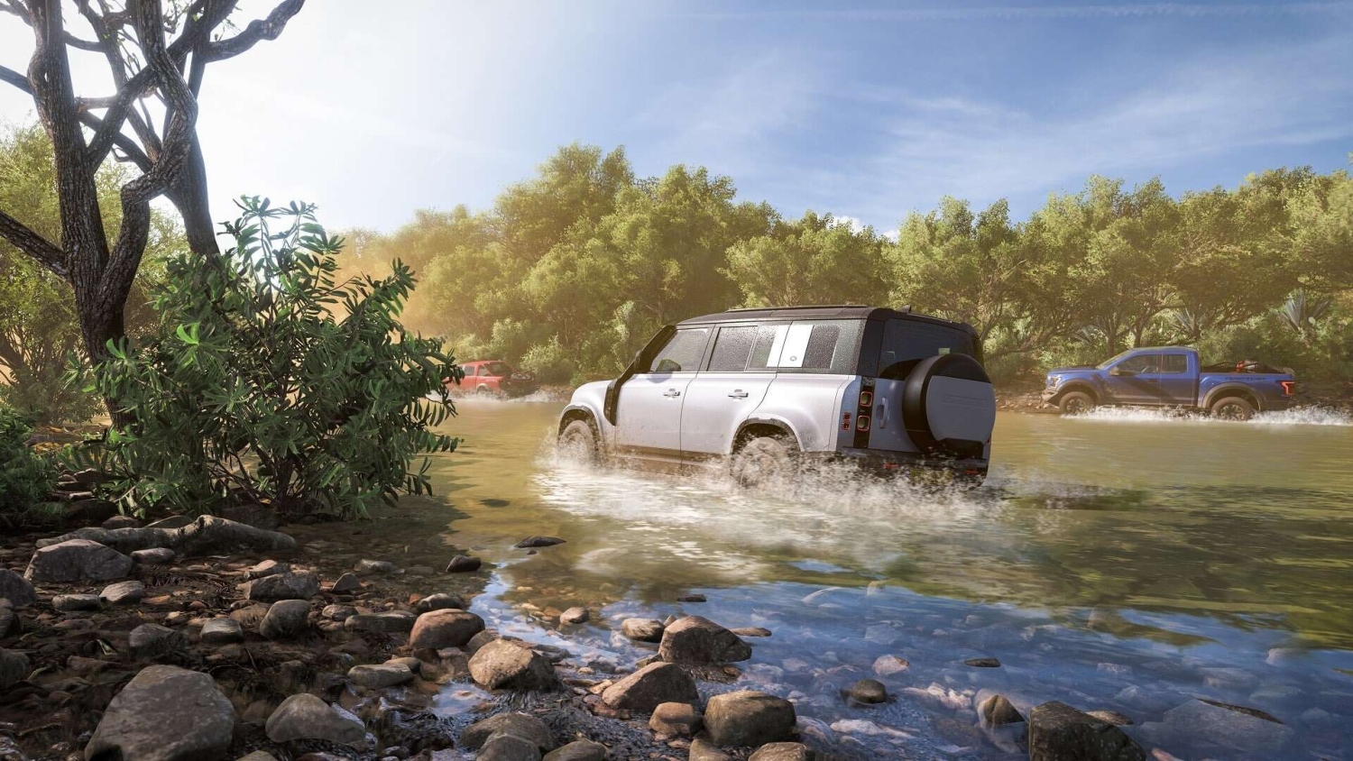 White off-road car with two other vehicles splashing through a shallow river surrounded by green trees