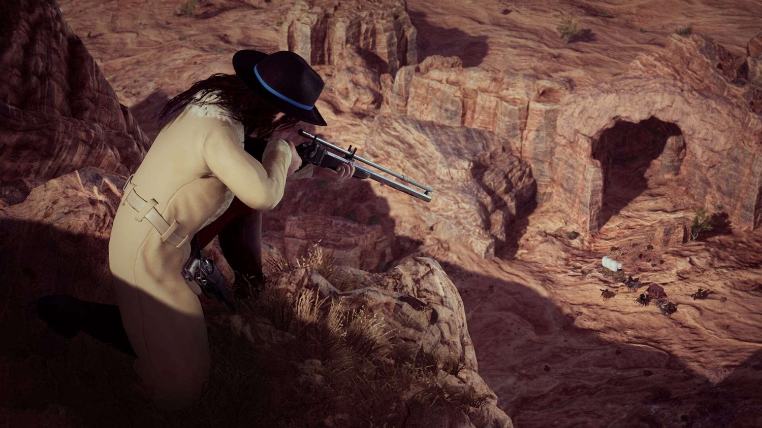 Person in wide-brimmed black hat and beige coat kneeling on rocky cliff aiming a long rifle at a wagon train below in a canyon