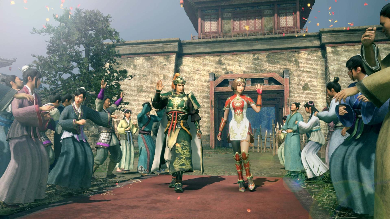 Two characters in traditional armour and dress wave while walking on a red carpet outside a fortress gate to a cheering crowd