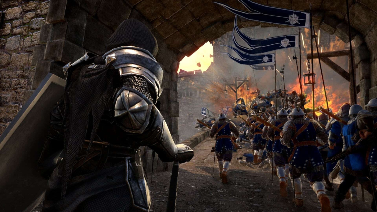 Armoured soldiers in blue advancing through a stone castle gate towards an explosion during a medieval battle