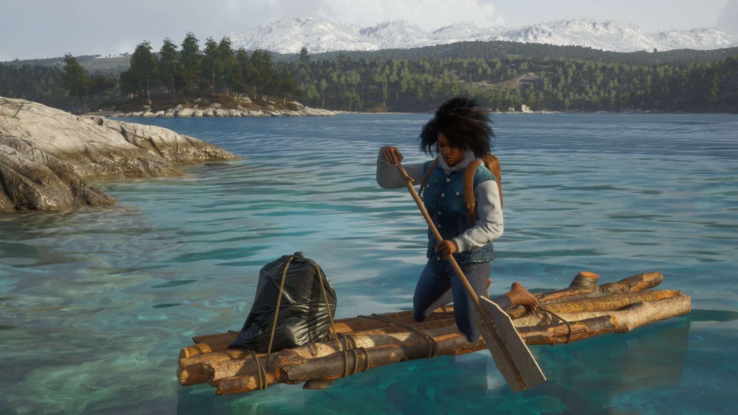 Person paddles a wooden raft with a backpack over clear blue water by rocky shore and forested hills