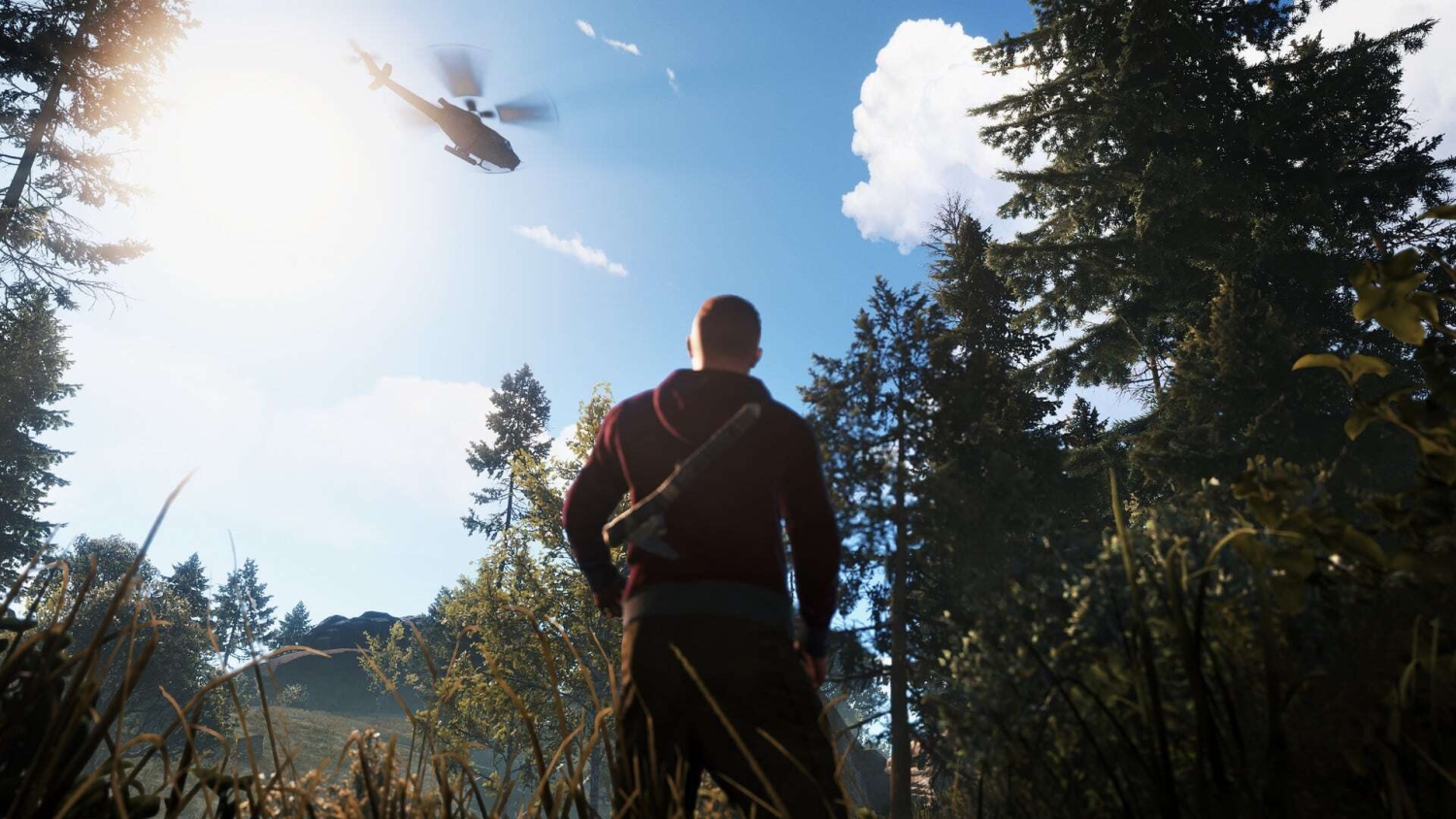 Man holding an axe standing in a dense forest looking up at a helicopter flying in bright sky