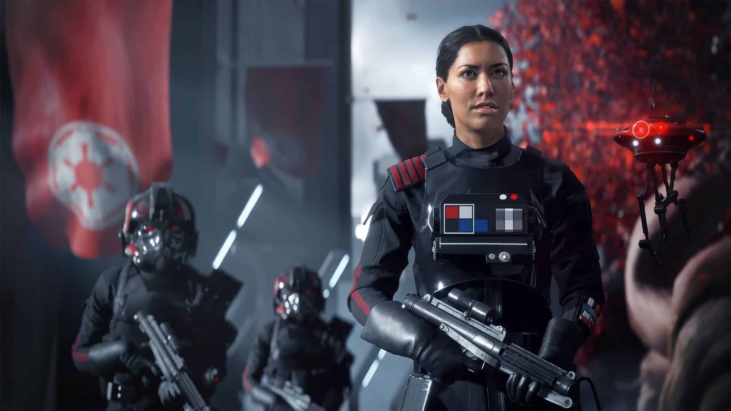 Female soldier in black armour with red markings standing with two similarly dressed soldiers behind, holding blasters in a dimly lit futuristic setting