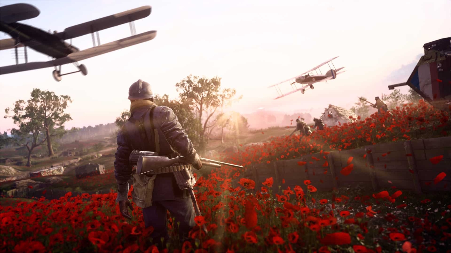 Soldier holding rifle stands in a red poppy field with biplanes flying overhead and other soldiers in trench