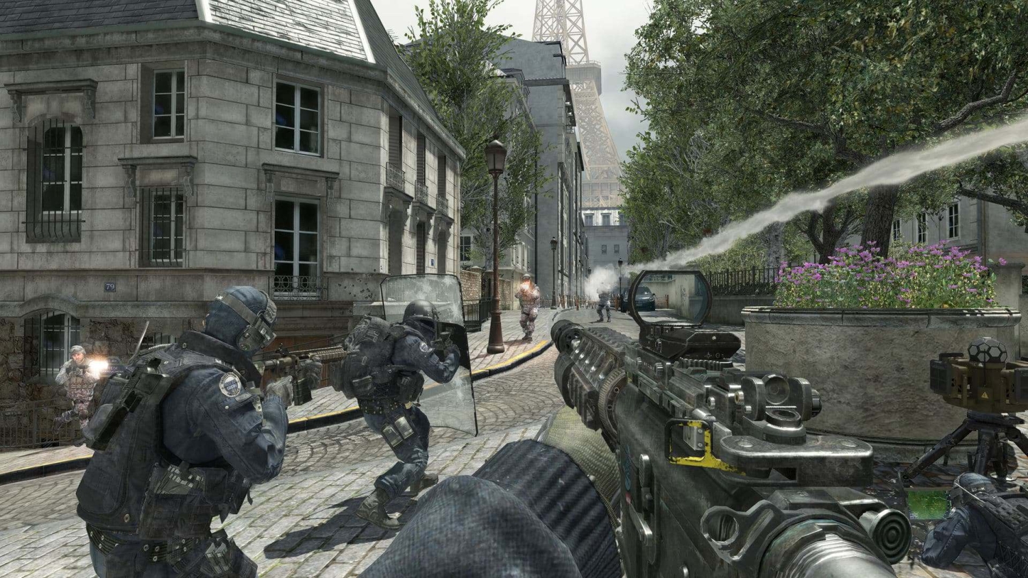 First-person shooter perspective with armed soldiers firing weapons on a Parisian street near the Eiffel Tower
