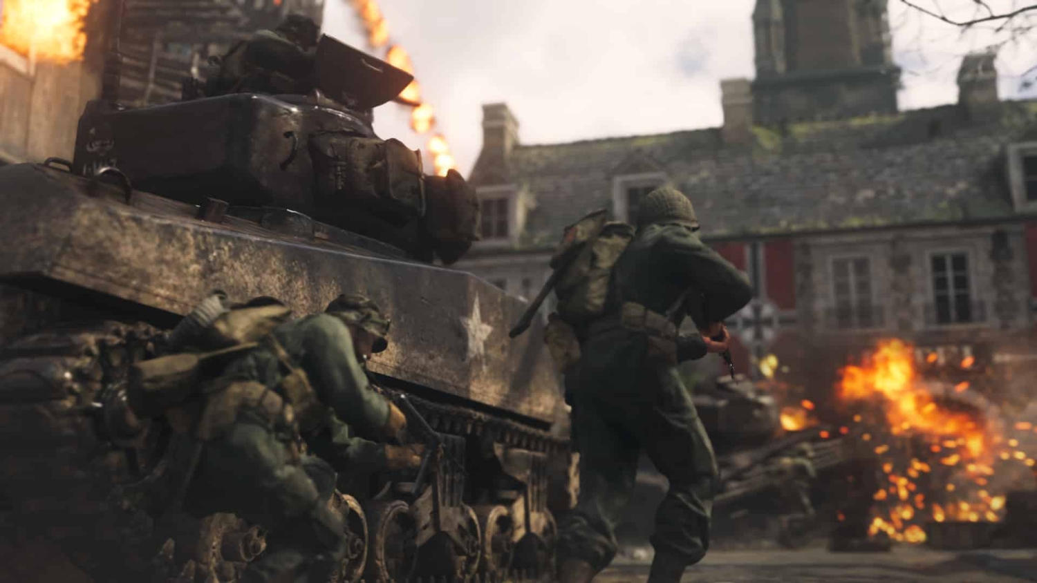 Two soldiers with rifles advancing beside a tank amid explosions in a war-torn urban setting