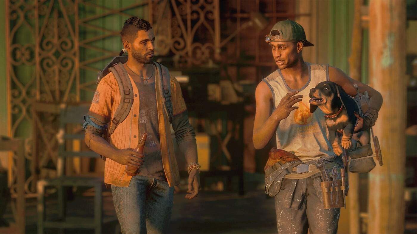 Two men indoors having a conversation, one holding a small dog, the other holding a bottle