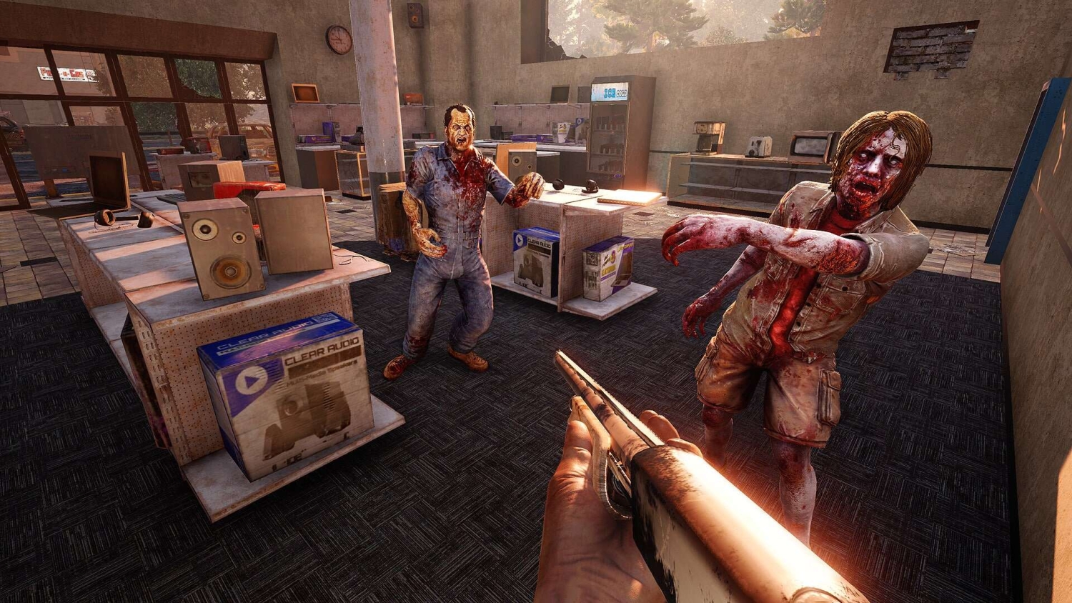 First-person view aiming a shotgun at two bloodied zombies inside a cluttered electronics store
