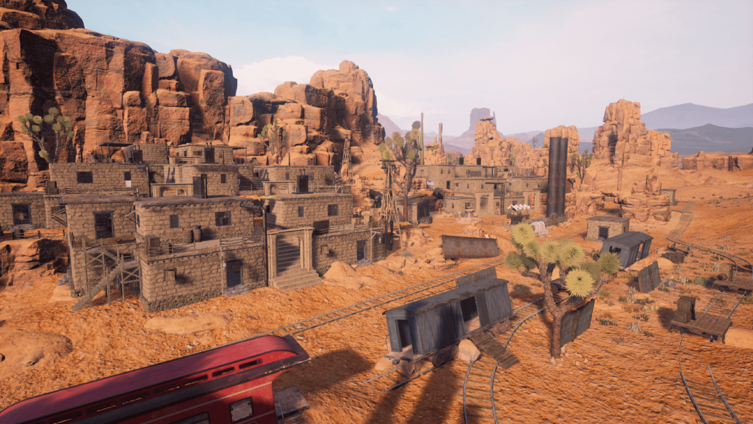 Desert town with stone buildings, rusty train tracks, and a red train car under rocky mesas