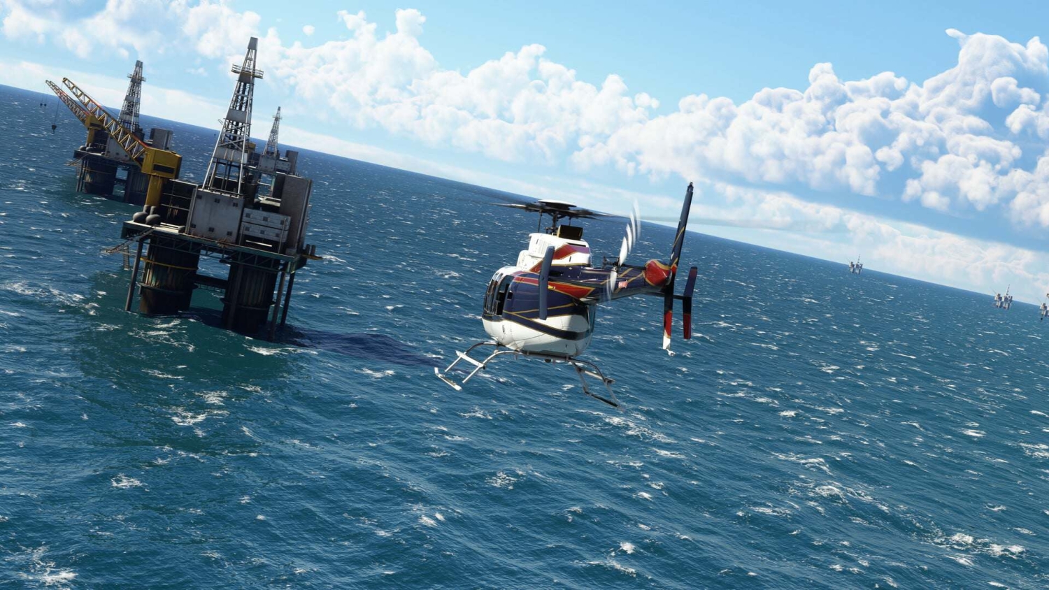 Helicopter flying over ocean near several offshore oil platforms under a partly cloudy sky