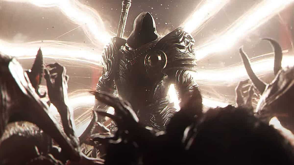 Armoured hooded figure stands before bright radiant light with shadowy hands reaching out in foreground