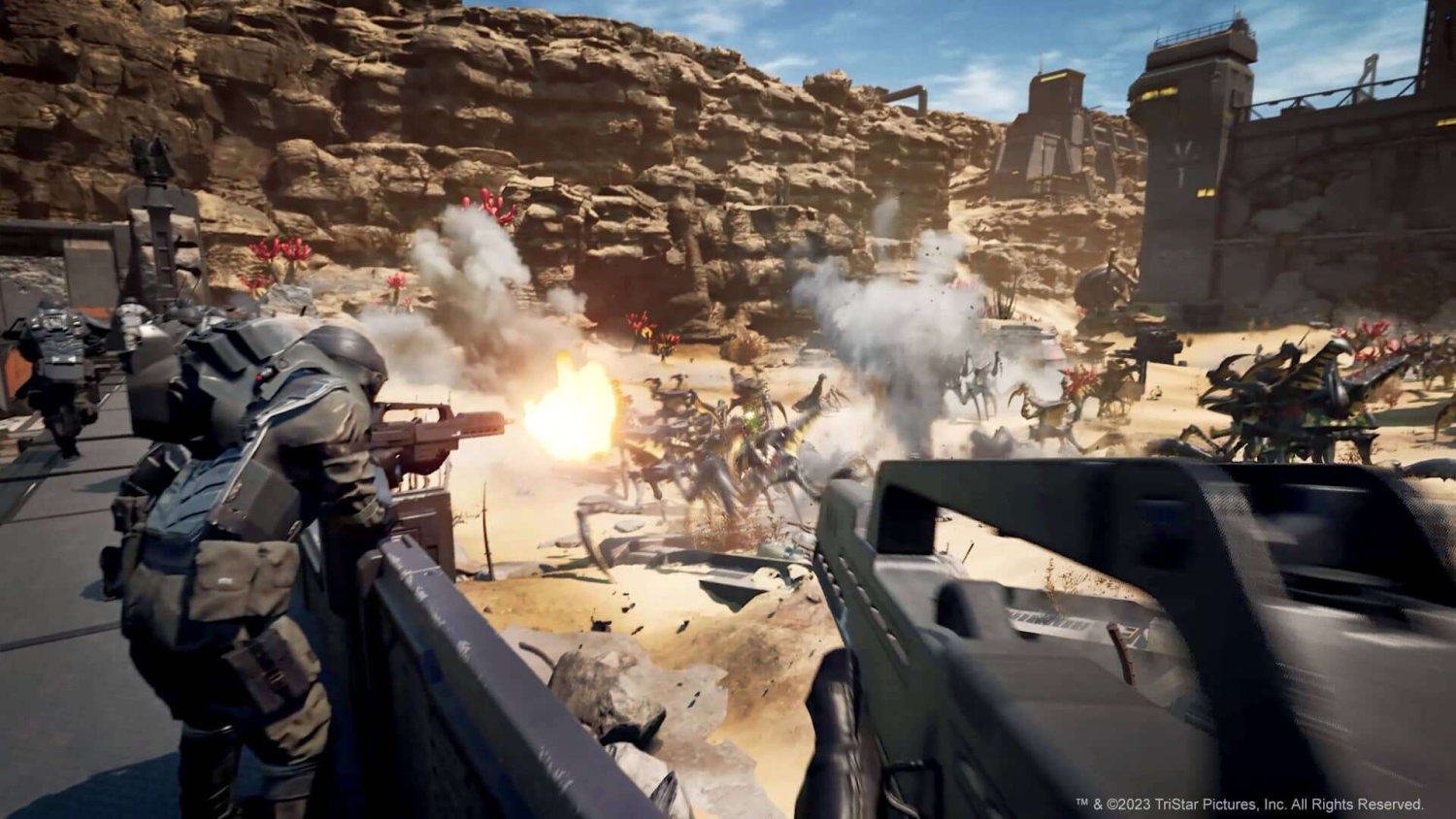 Soldiers wearing advanced armour firing weapons at insect-like alien creatures in rocky desert canyon