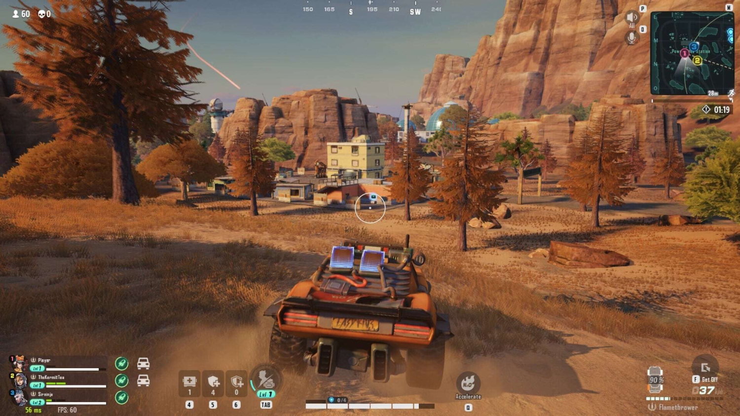 View from a vehicle driving towards a small settlement with autumn trees in a rocky desert environment
