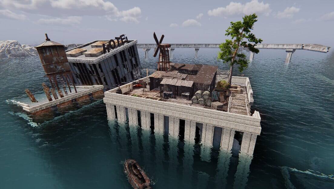 Ruined hotel and wooden structures on a small platform surrounded by water with a water tower and windmill