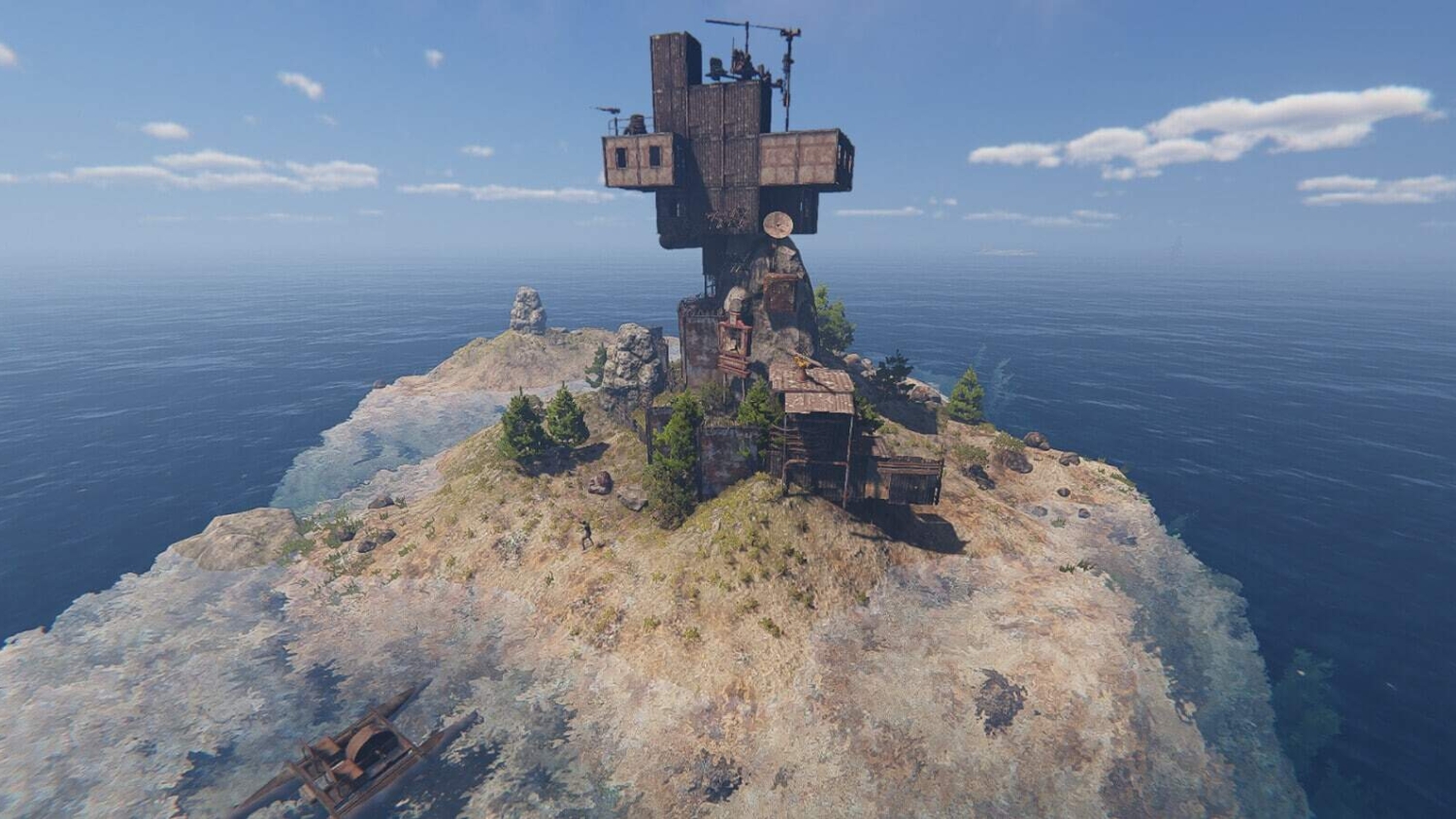 Rugged small island featuring a tall, irregular metal and wooden structure surrounded by calm sea under blue sky
