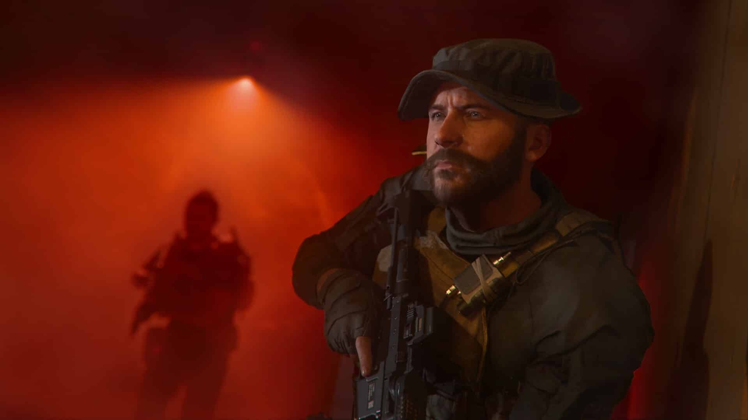 Bearded soldier in tactical gear holding a rifle in a dimly lit smoky room with red lighting