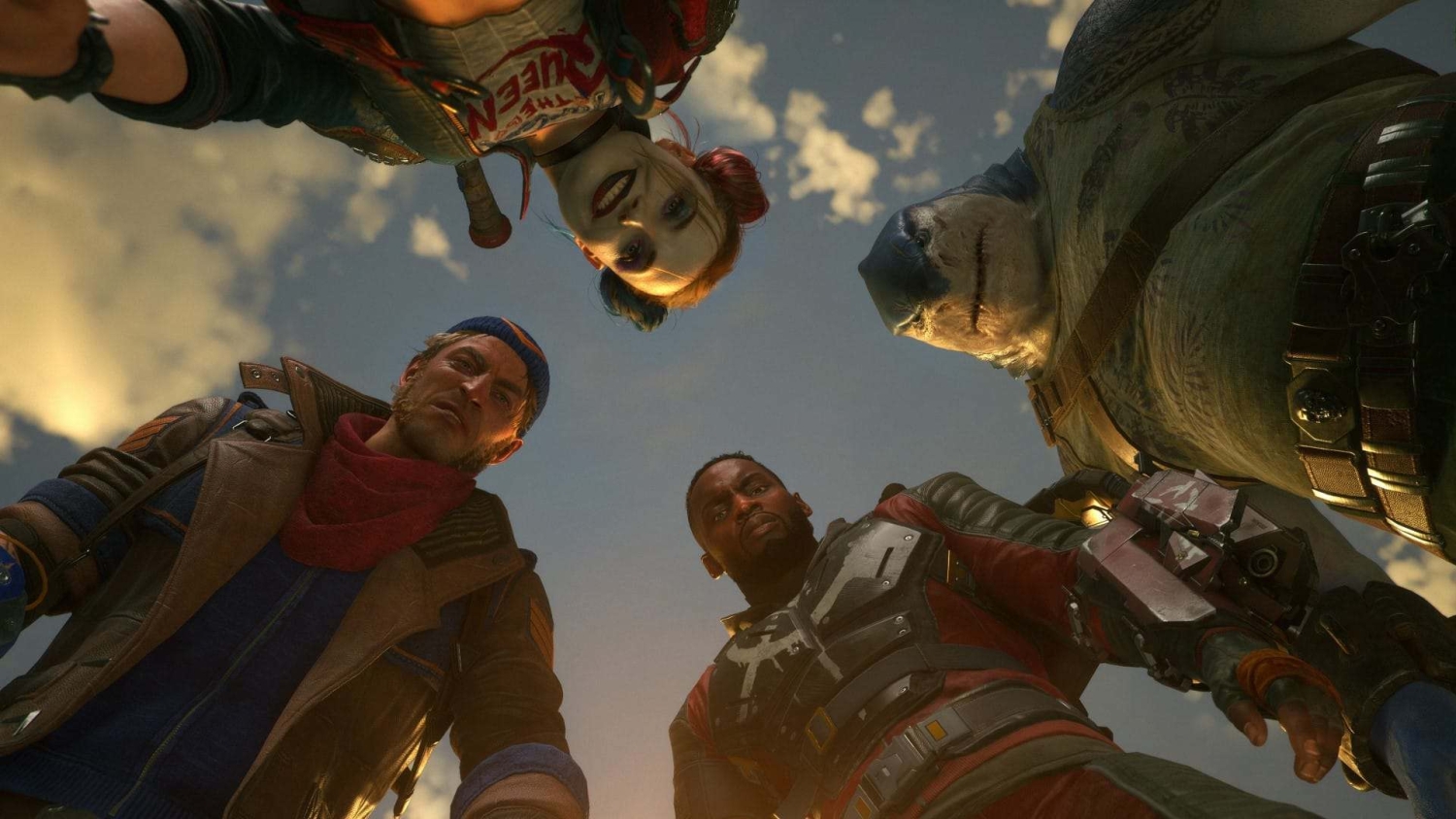 Four colourful costume-wearing characters looking downwards under a cloudy sky from a low perspective