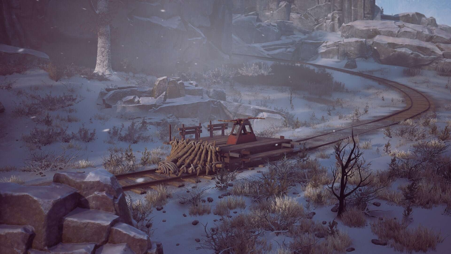 Wooden handcar resting on snowy railway tracks surrounded by rocks and winter vegetation