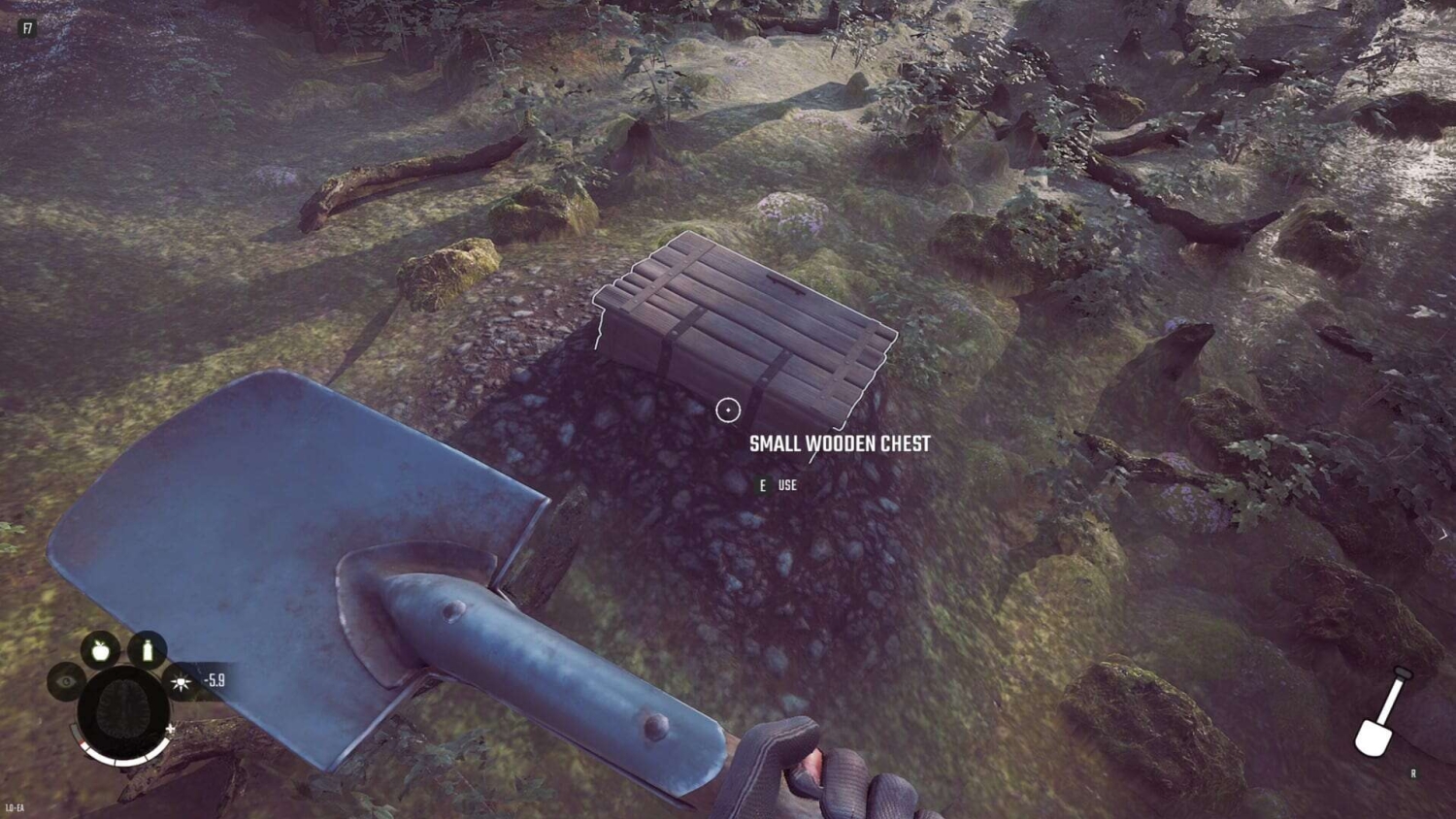 First-person view of a hand holding a metal shovel above a small wooden chest in a mossy forest clearing