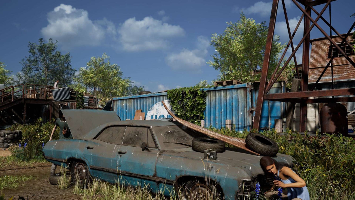 Blue rusty old car with open bonnet and tyres weighing it down in an overgrown, abandoned campsite