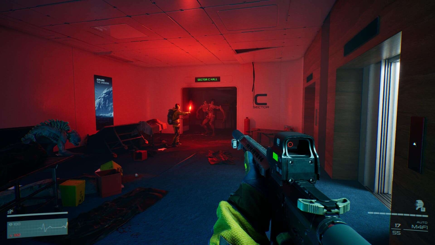 First-person view of player holding a rifle in a dim corridor lit by red light, facing a character holding a flare and a creature