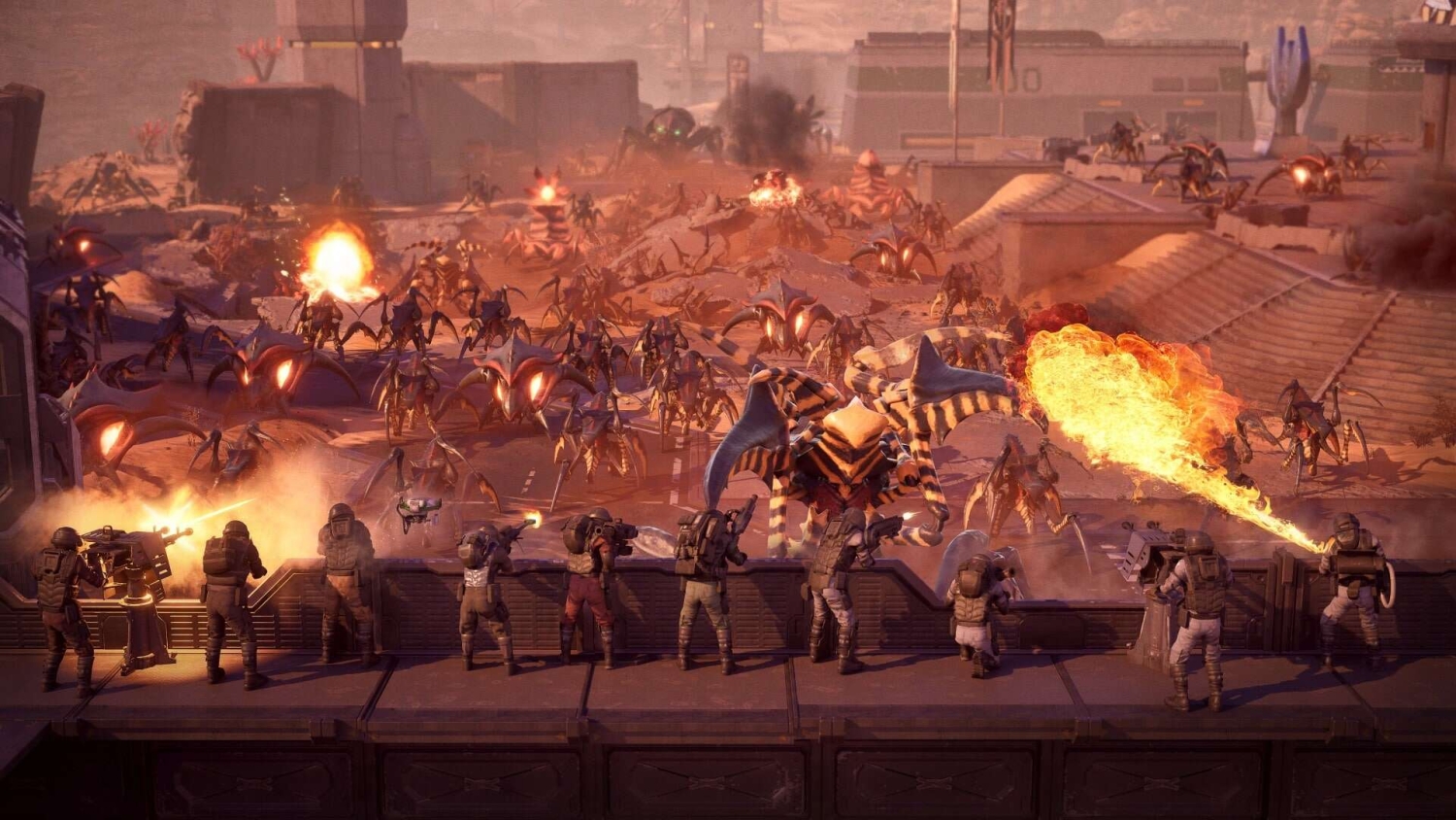 Soldiers firing weapons and flamethrowers from a barricade as large insect-like creatures attack on a dusty battlefield