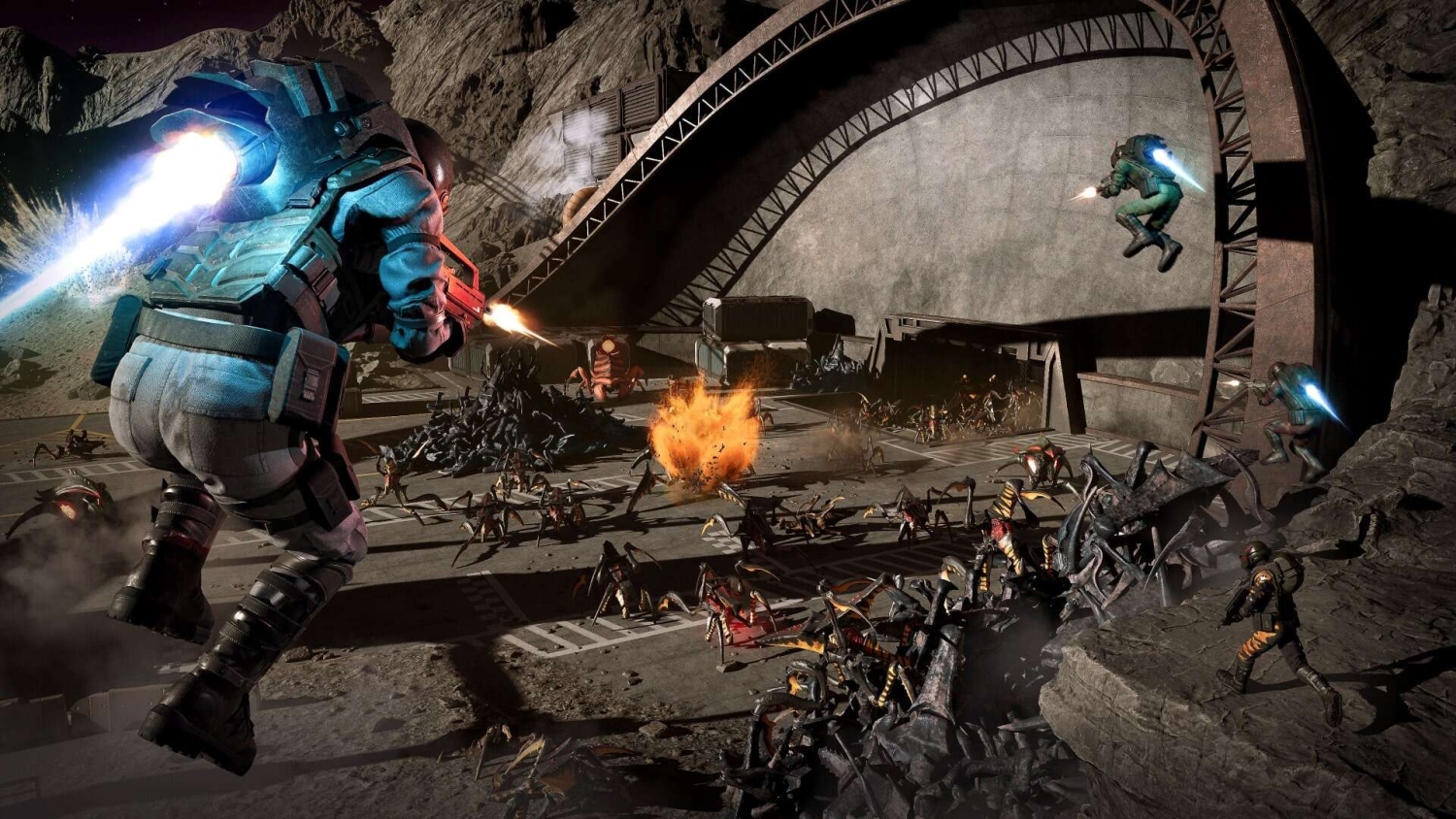 Armoured soldiers with jetpacks firing weapons at swarming insect-like creatures near a rocky base
