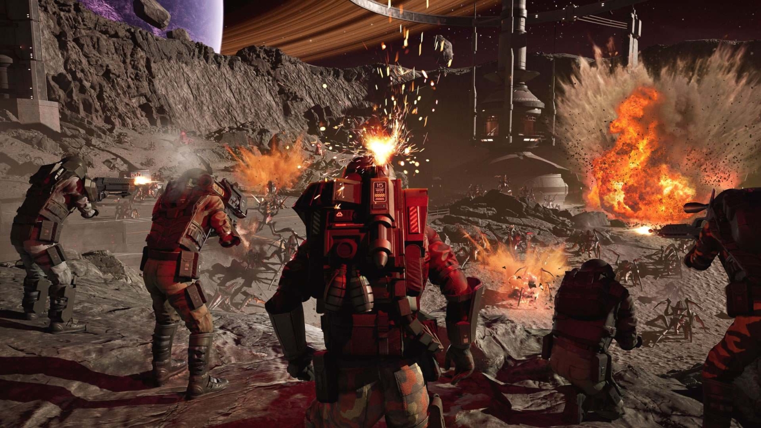 Five soldiers in advanced armour firing weapons at numerous alien insects on rocky terrain with large explosions