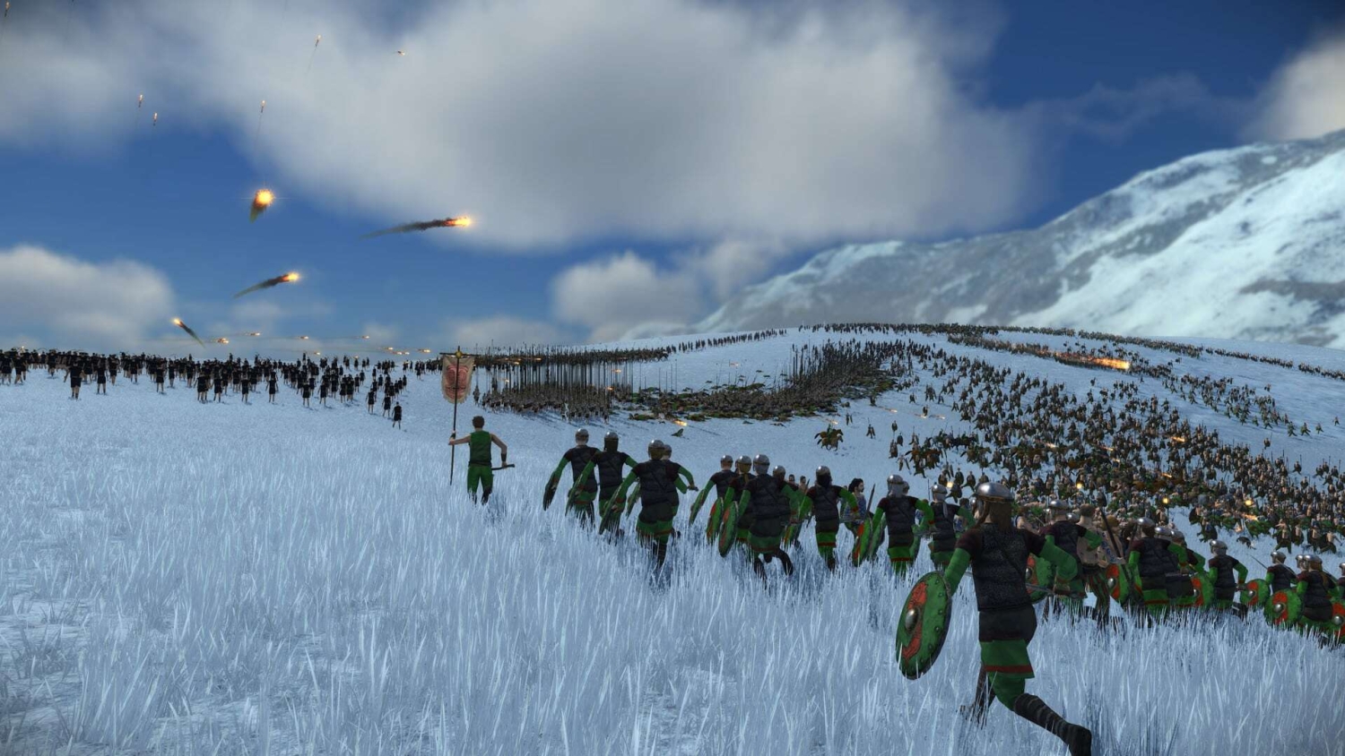 Roman soldiers in green and black advancing across a snowy field while flaming projectiles fly in the sky during a large battle