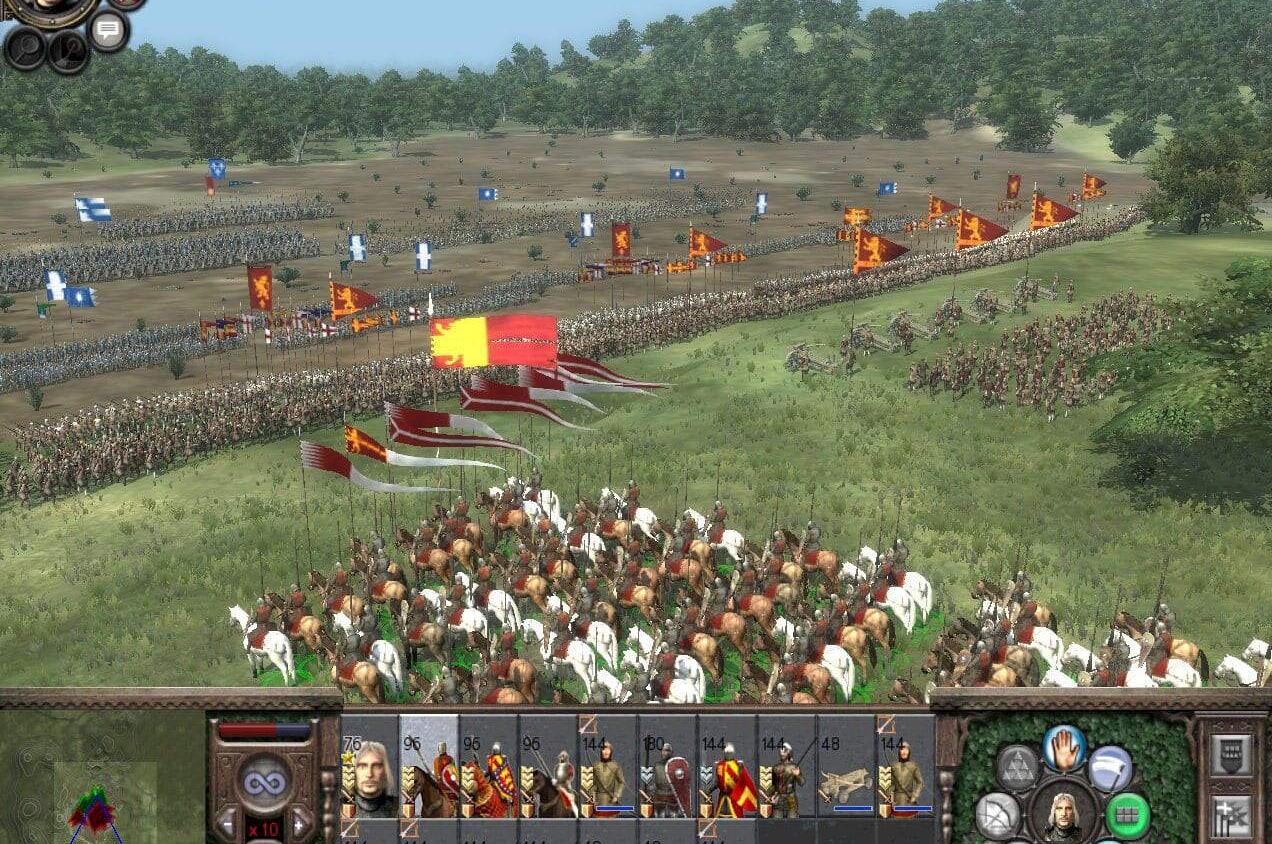 Large medieval battlefield with infantry and cavalry units in formation, banners flying above ranks