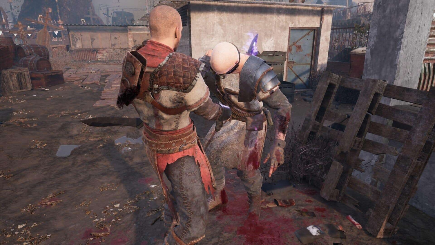 Two men in medieval-style armour fighting closely with blood on their clothes and ground